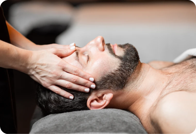 Homme détendu pendant un soin visage et massage au cabinet PRISME à Treillières près de Nantes