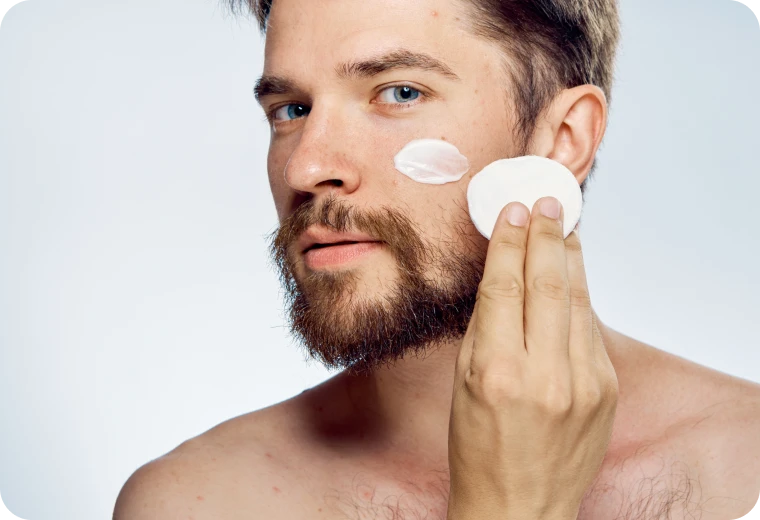 Homme appliquant un soin nettoyant sur le visage dans le cadre d'une routine skincare